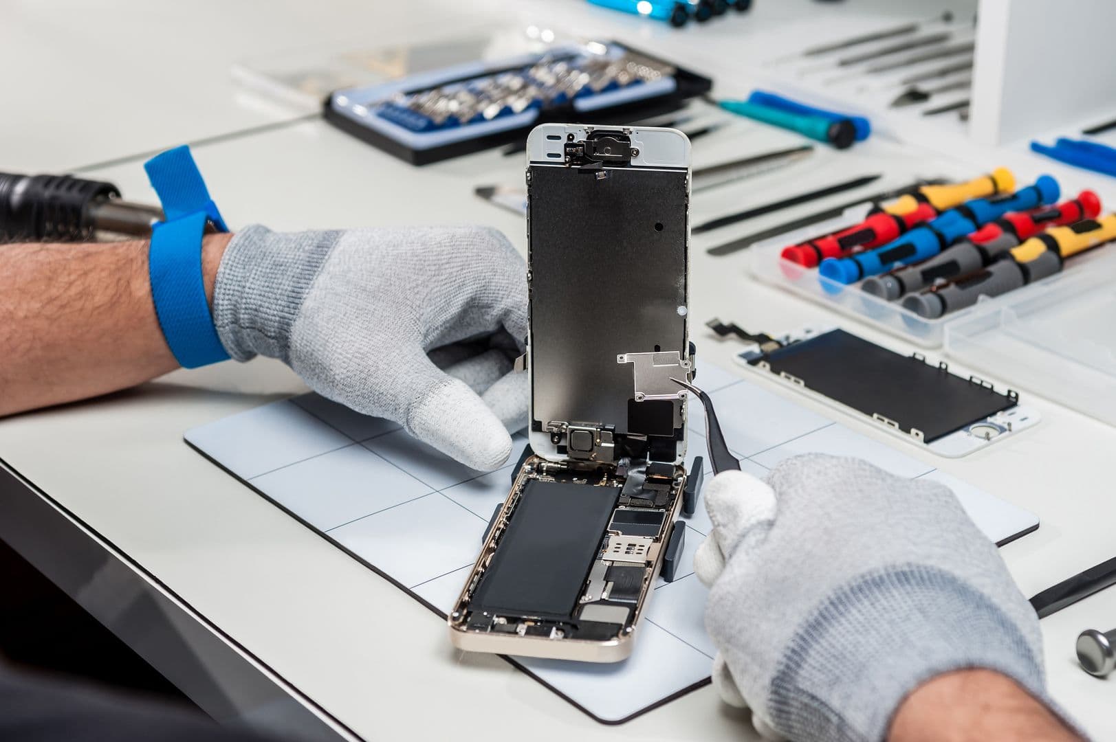 MTW Repair technician repairing a smartphone at the Money Talks Wireless shop in Bridgeport, CT
