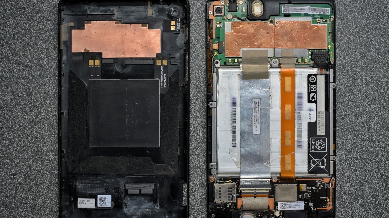 Smartphone opened up on a workbench with the lithium-ion battery and logic board exposed
